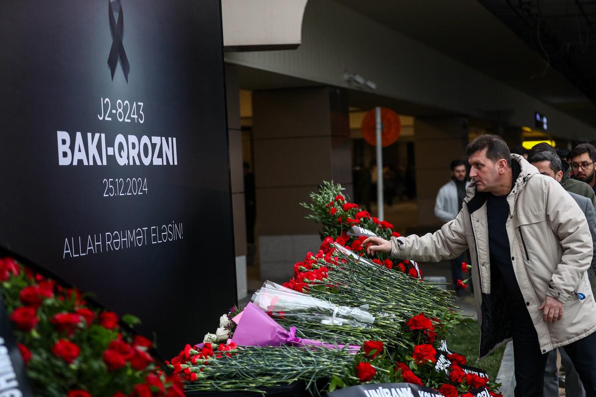 Citizens lay flowers in memory of victims of the Azerbaijan Airlines’ Embraer 190 that crashed near the Kazakhstan’s airport of Aktau, at the Heydar Aliyev International Airport outside on December 26, 2024 in Baku, Azerbaijan.