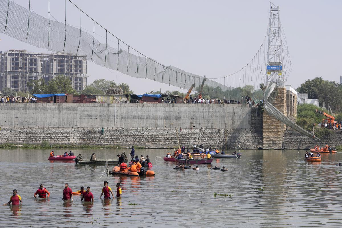 Rescuers in boats search the Machu River next to a collapsed cable bridge in the city of Morbi, Gujarat, October 31, 2022.