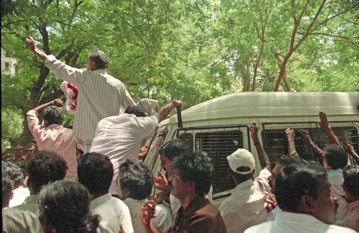 DMK cadre surround the police van carrying Mr. Stalin in Chennai on June 30, 2001