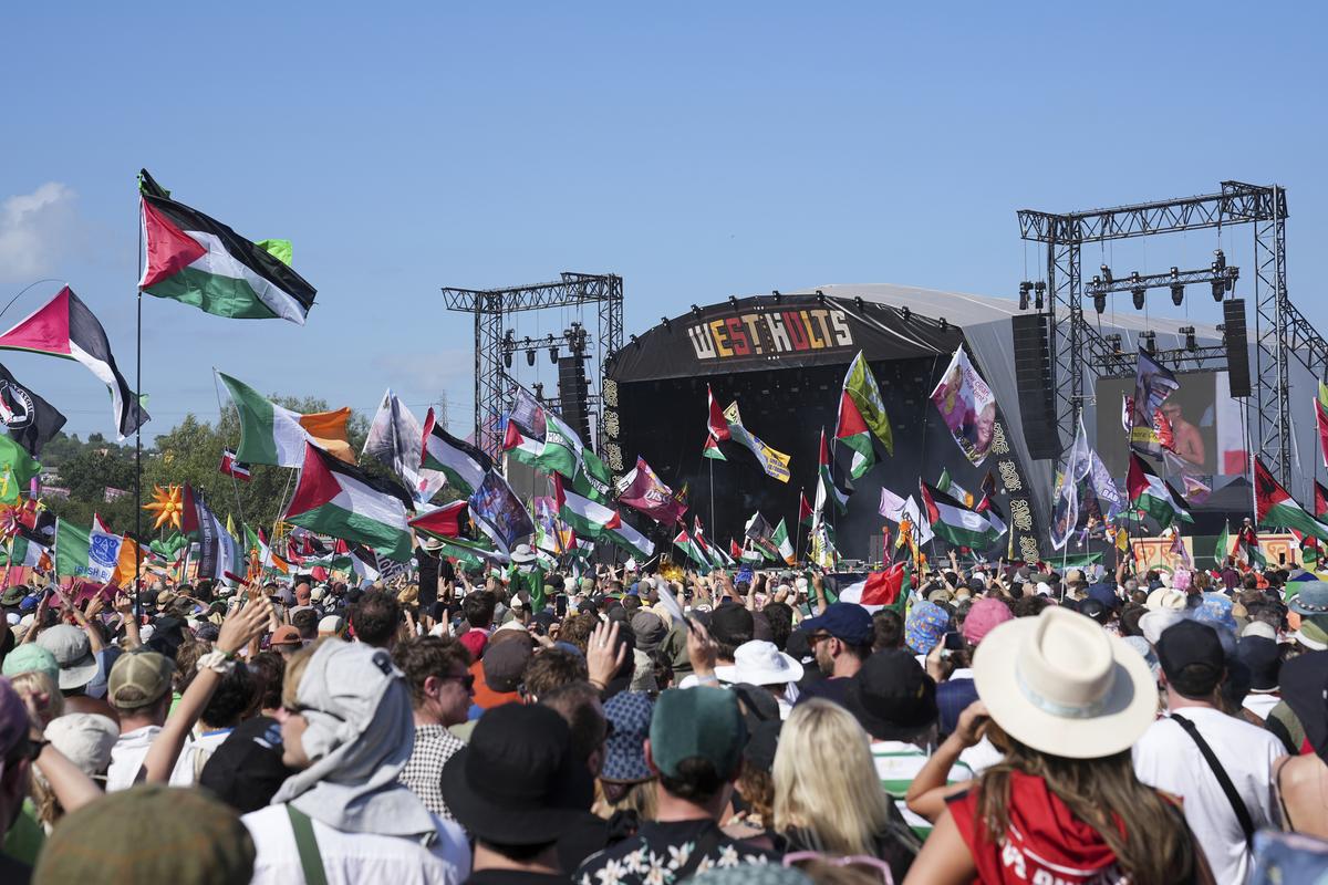 Festivalgoers watch hip hop trio Kneecap perform during the Glastonbury Festival in Worthy Farm, Somerset, England, Saturday, June 28, 2025. 