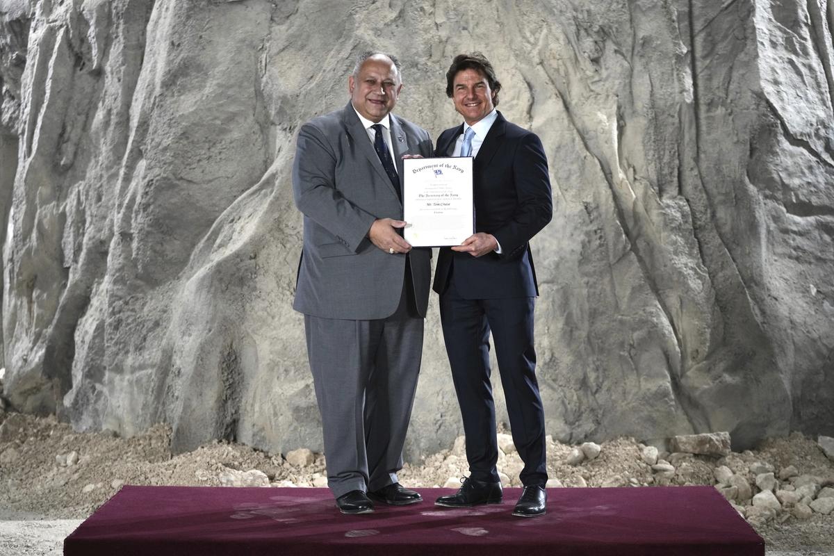 Tom Cruise, right, receives a Navy Distinguished Public Service Award from The United States Secretary of the Navy Carlos Del Toro at the Longcross South Studios, in Runnymede, Surrey, England, Tuesday, Dec. 17, 2024.