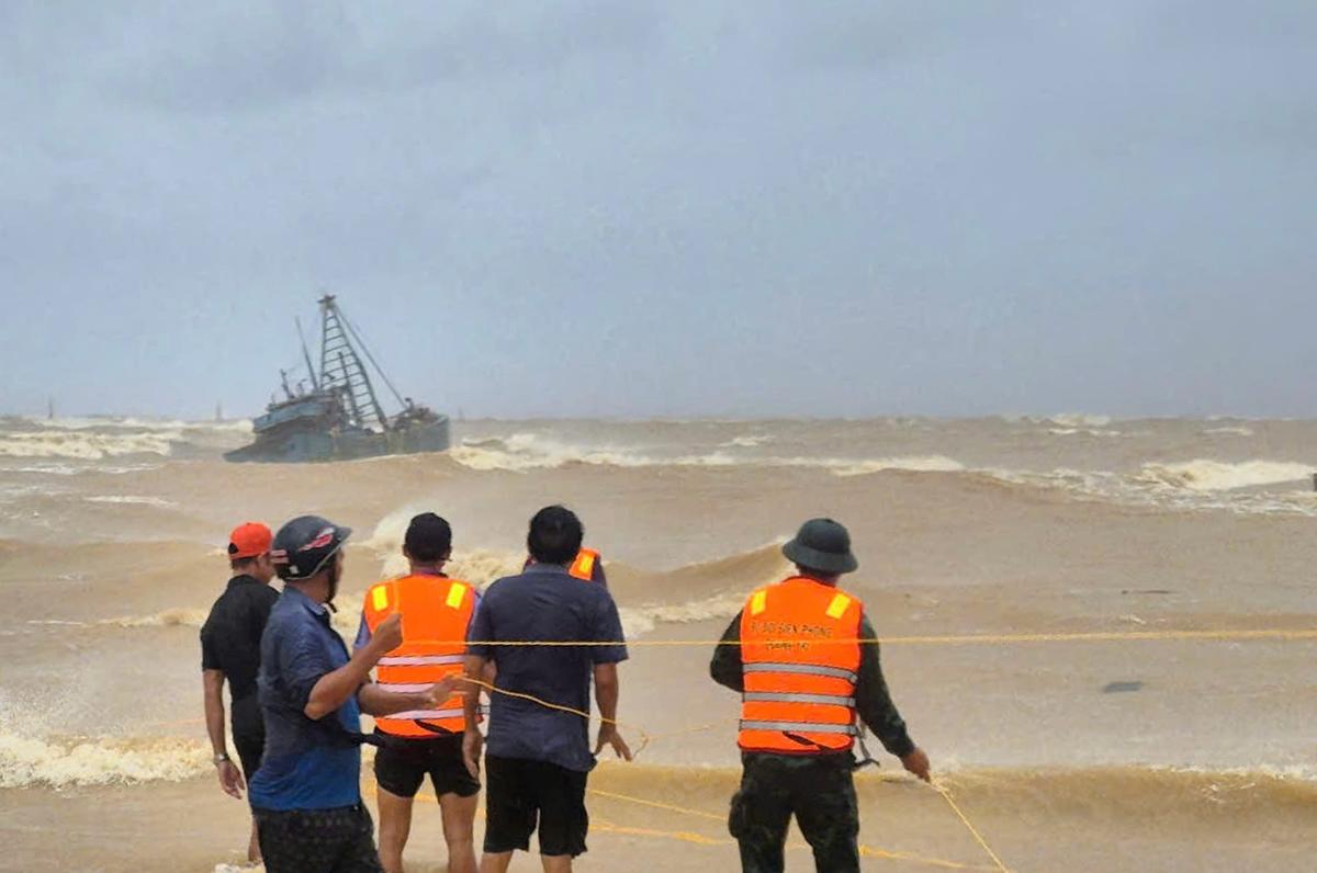 As pessoas trabalham para resgatar pescadores em um barco de pesca preso devido ao tufão Bualoi em Quang Tri, Vietnã no domingo, 28 de setembro de 2025. 