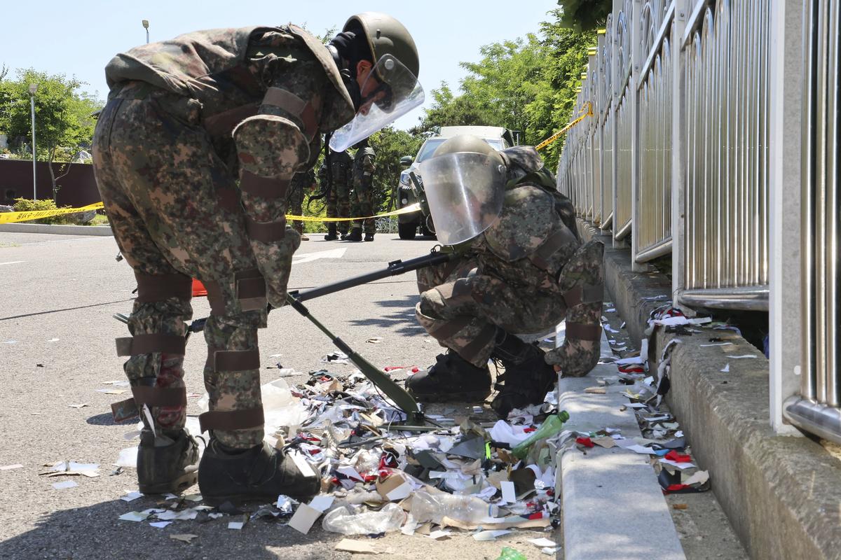 South Korean soldiers wearing protective gears check the trash from a balloon presumably sent by North Korea, in Incheon, South Korea, Sunday, June 2, 2024. North Korea launched hundreds of more trash-carrying balloons toward the South after a similar campaign a few days earlier, according to South Korea’s military, in what Pyongyang calls retaliation for activists flying anti-North Korean leaflets across the border. 