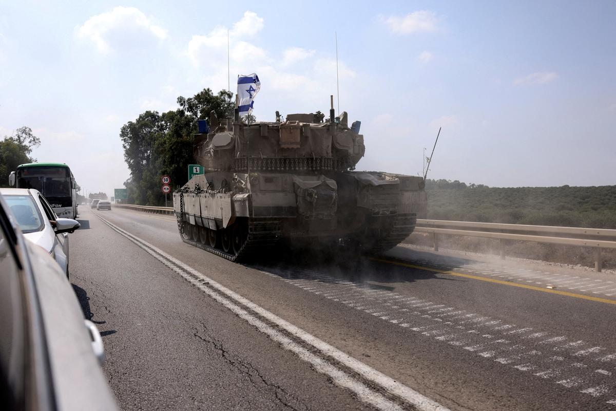 An Israeli tank drives on a road following a mass infiltration by Hamas gunmen from the Gaza Strip, near Sderot in southern Israel.