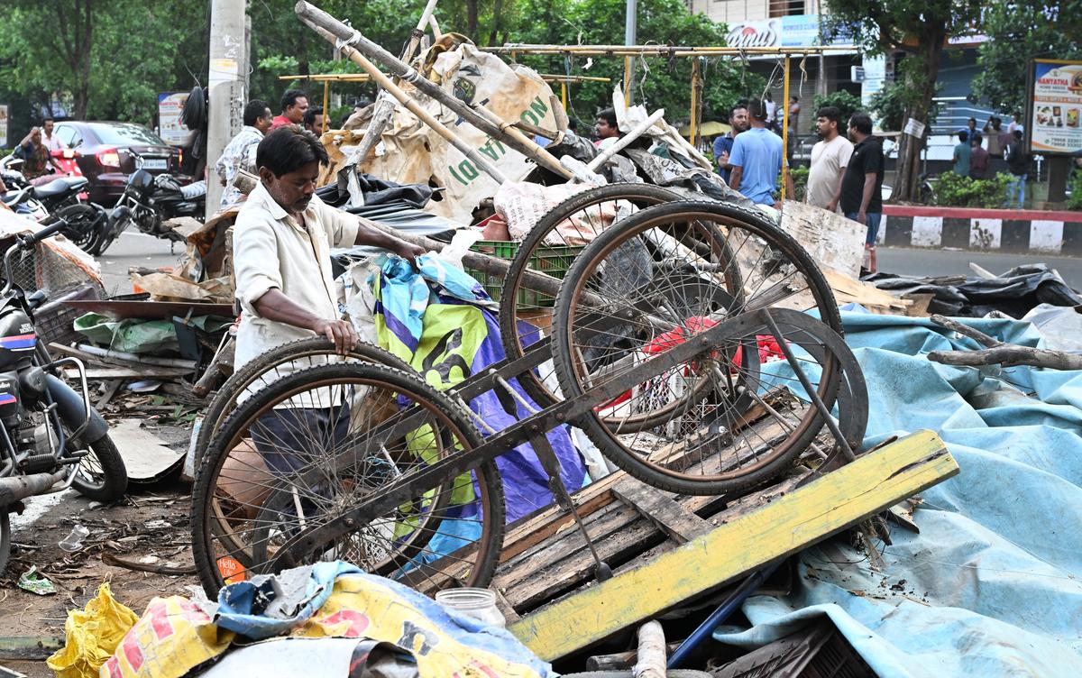A street vendor salvages his cart and other belongings after the GVMC’s anti-encroachment drive at Seethammadhara in Visakhapatnam.