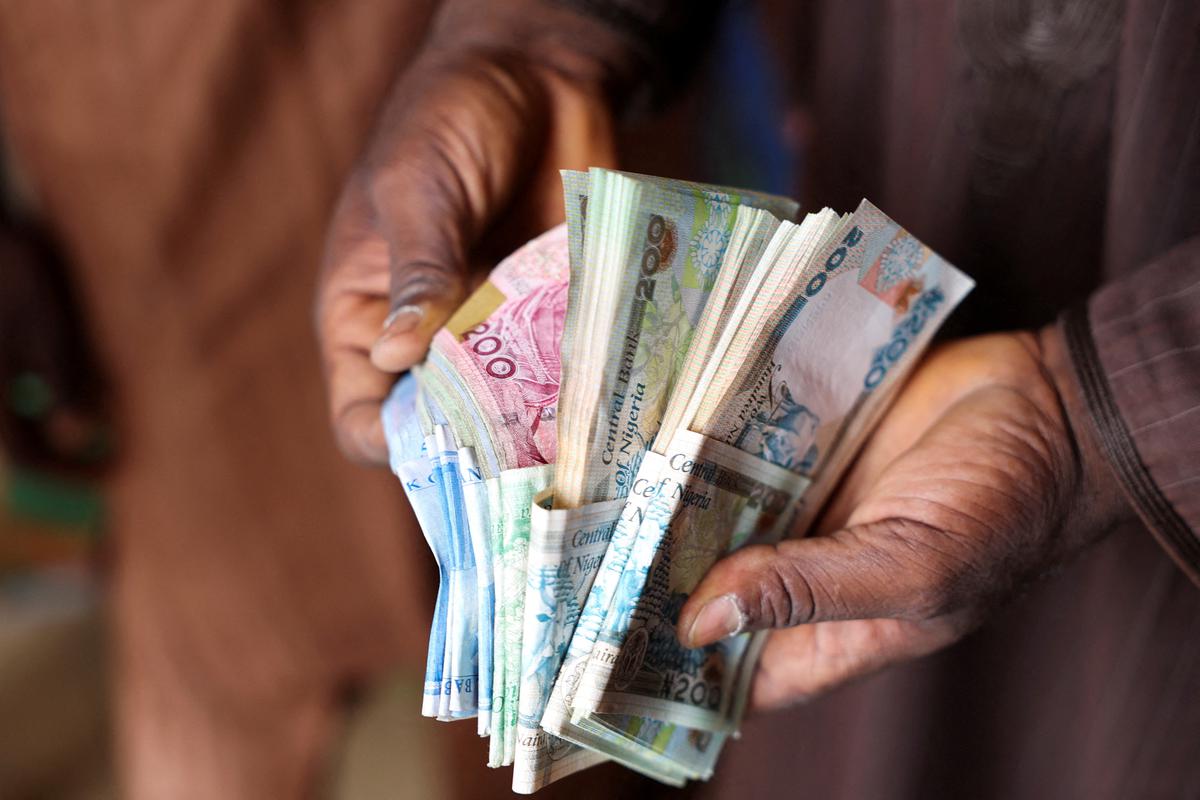 File picture of a man counting Nigerian naira notes in a market place in Yola, Nigeria