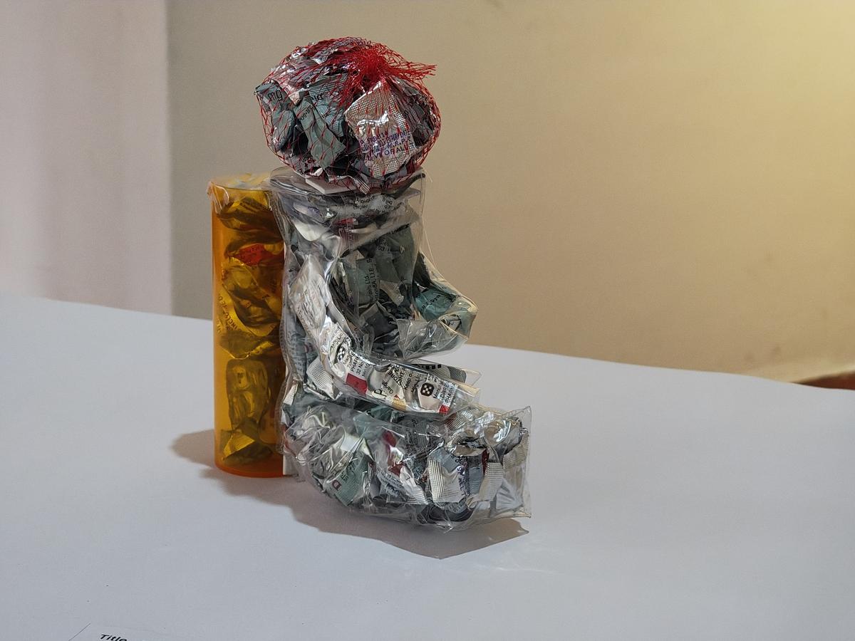 The Sitting Artist, a sculpture made of medicine strips at Lines of Flight