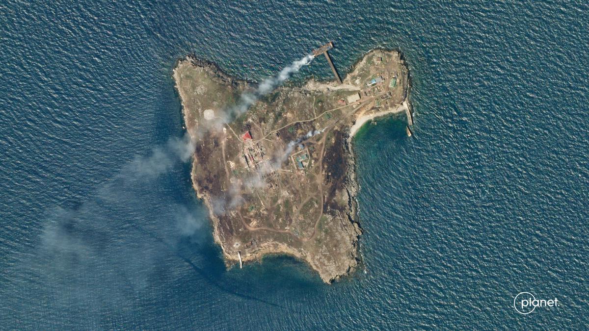 A satellite image shows smoke rising from Snake Island, off the coast of Ukraine