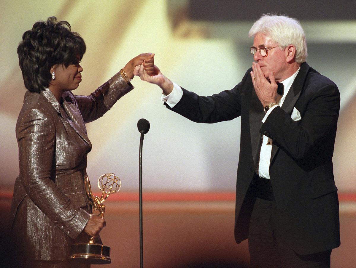 Phil Donahue blows a kiss to Oprah Winfrey as she presents him with a Lifetime Achievement Award at the 23rd Annual Daytime Emmy Awards in New York on May 22, 1996. File.