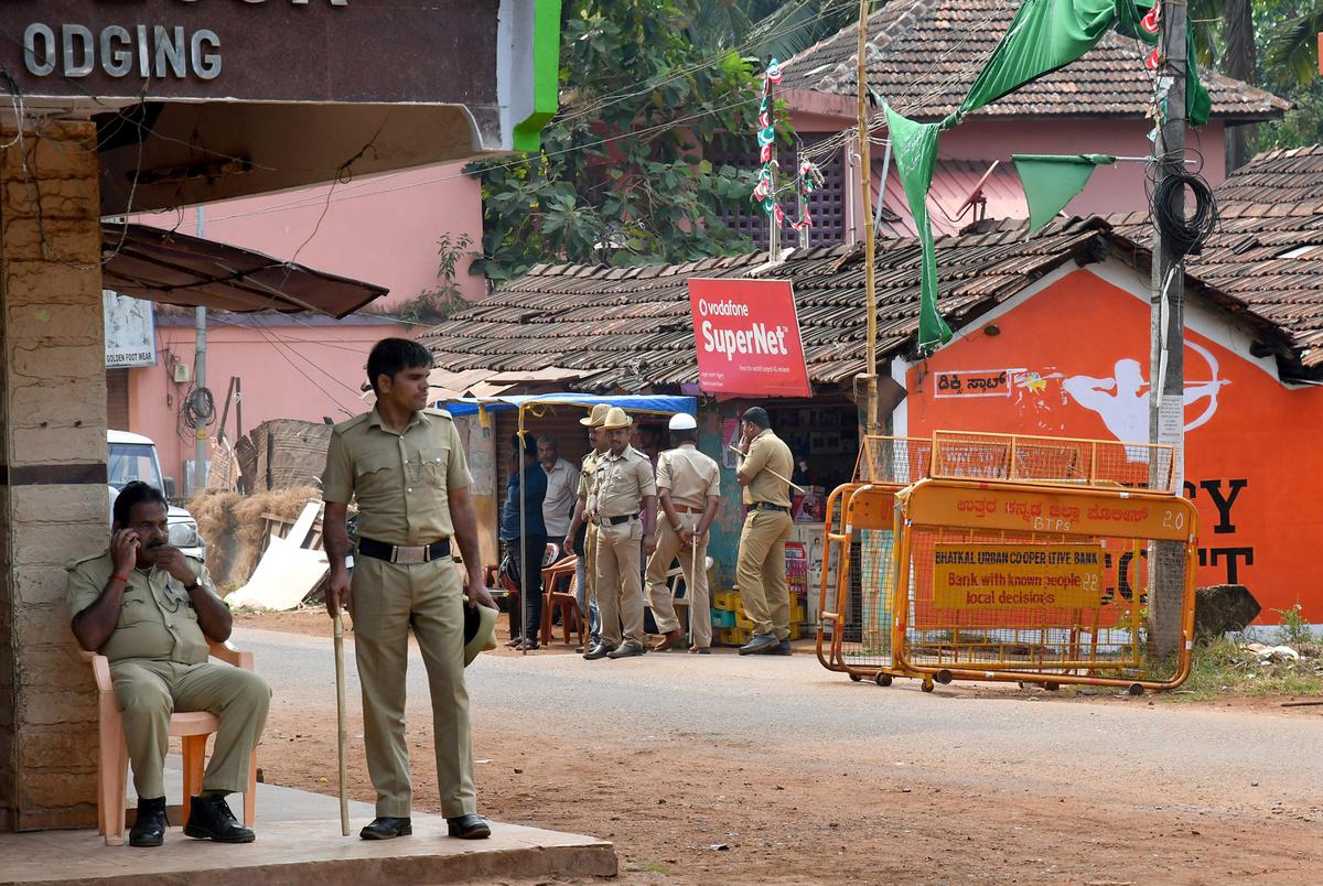Police officers stand near the spot where Paresh Mesta's body was found in Honnavara.  image file