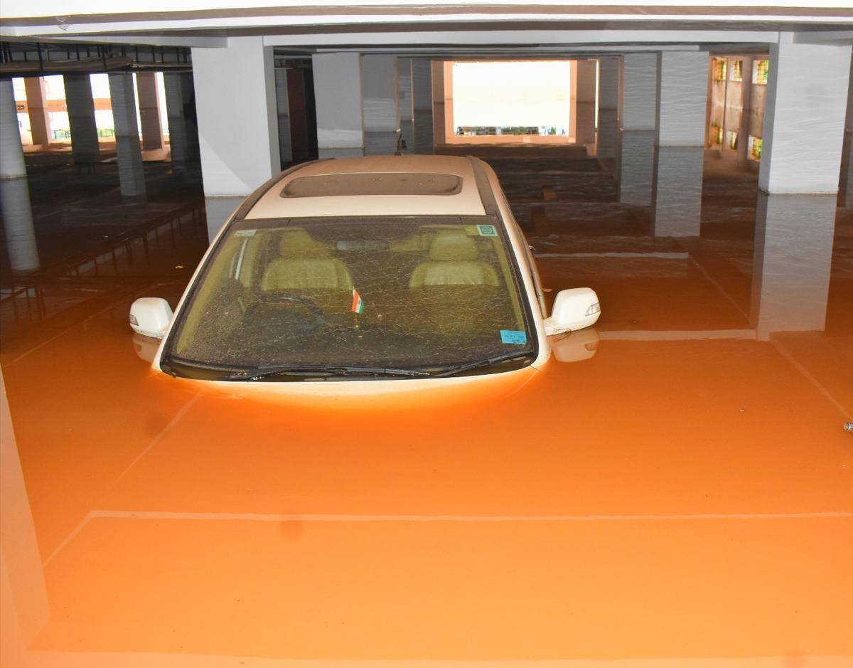 A car surrounded by muddy water in the basement of an apartment complex at Shirur Park in Hubballi following incessant rainfall on Wednesday evening.