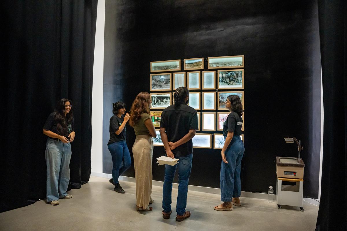 Visitors looking at a photo essay about the Kolar Gold Fields.