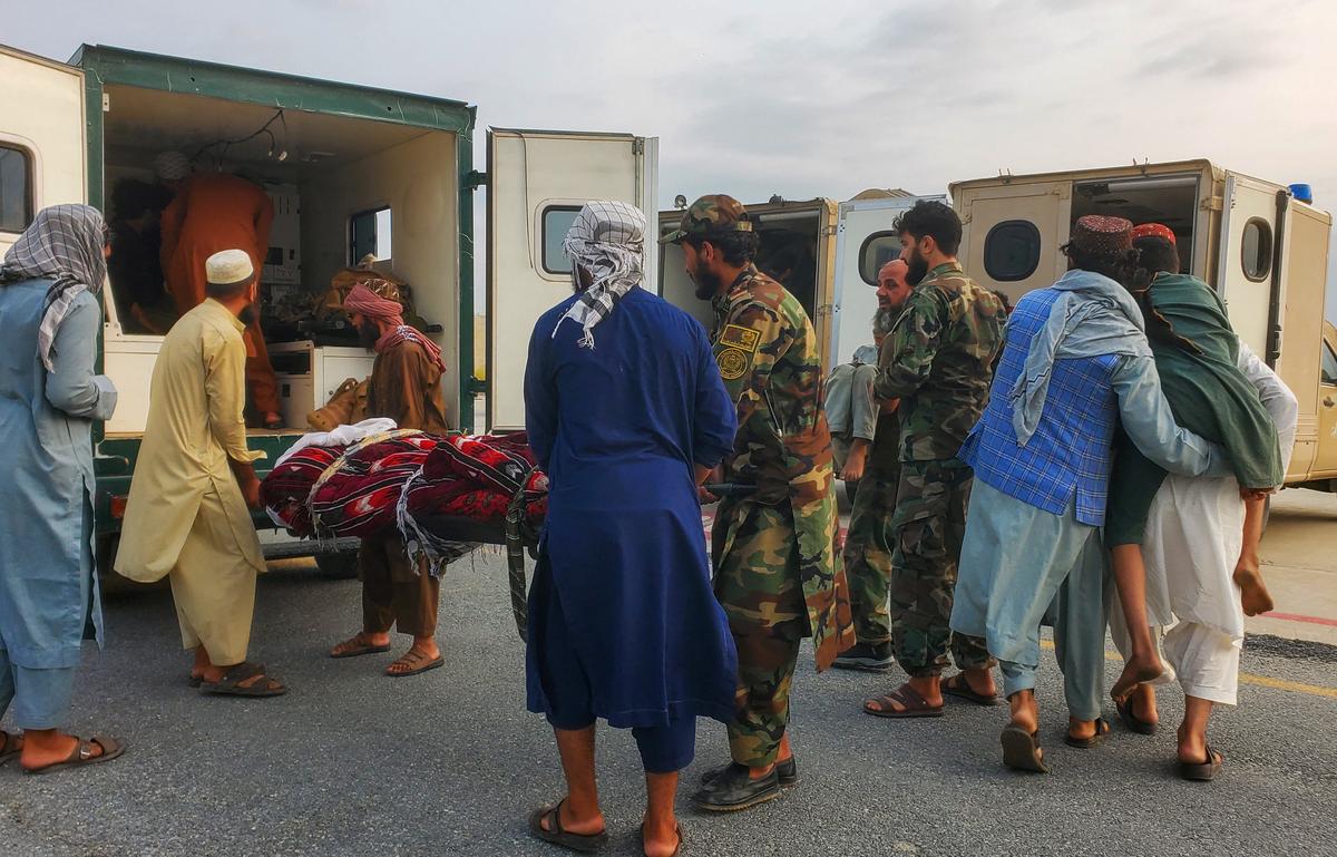 Taliban soldiers and civilians carry earthquake victims to an ambulance at an airport in Jalalabad, Afghanistan, on September 1, 2025