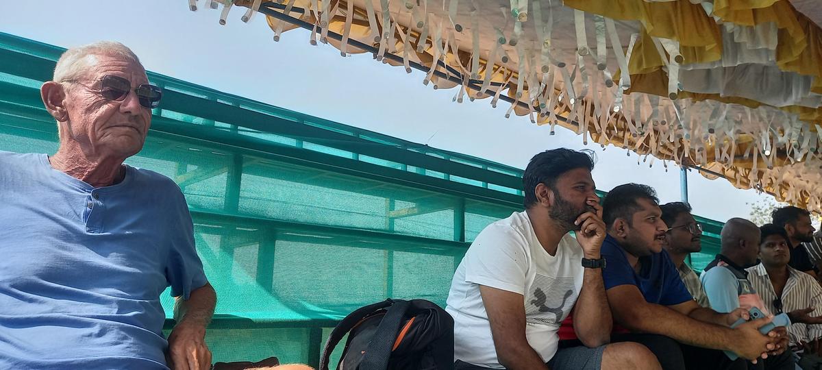 UK citizen Ian and software engineer Bharath Gowda from Bengaluru watching the first day of the Ranji Trophy final between Karnataka and Jammu & Kashmir from a makeshift stand at the KSCA stadium in Hubballi on February 24, 2026.