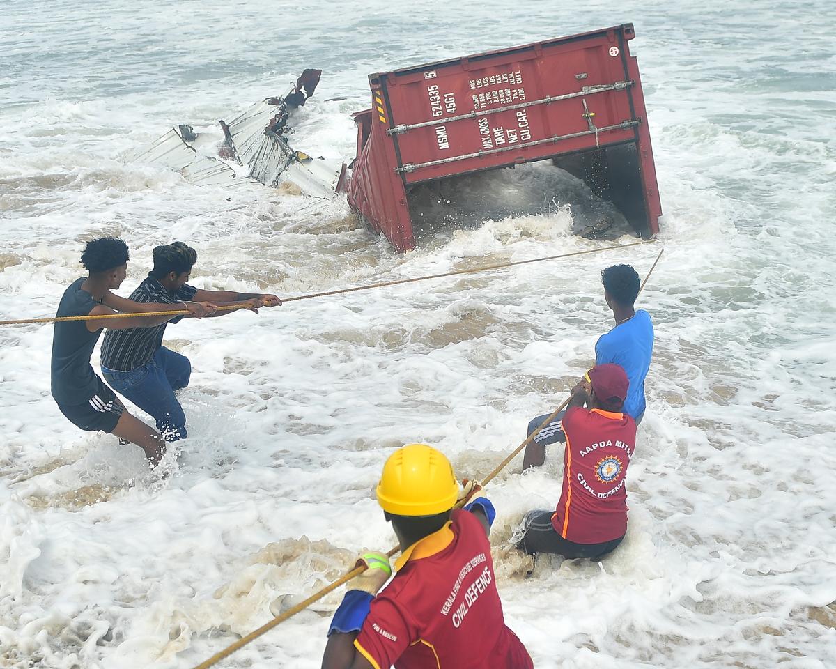 Civil defense volunteers pulling a container from sunken Liberian ship MSC ELSA 3 that washed ashore on to the coast of poovar in Thiruvananthapuram.