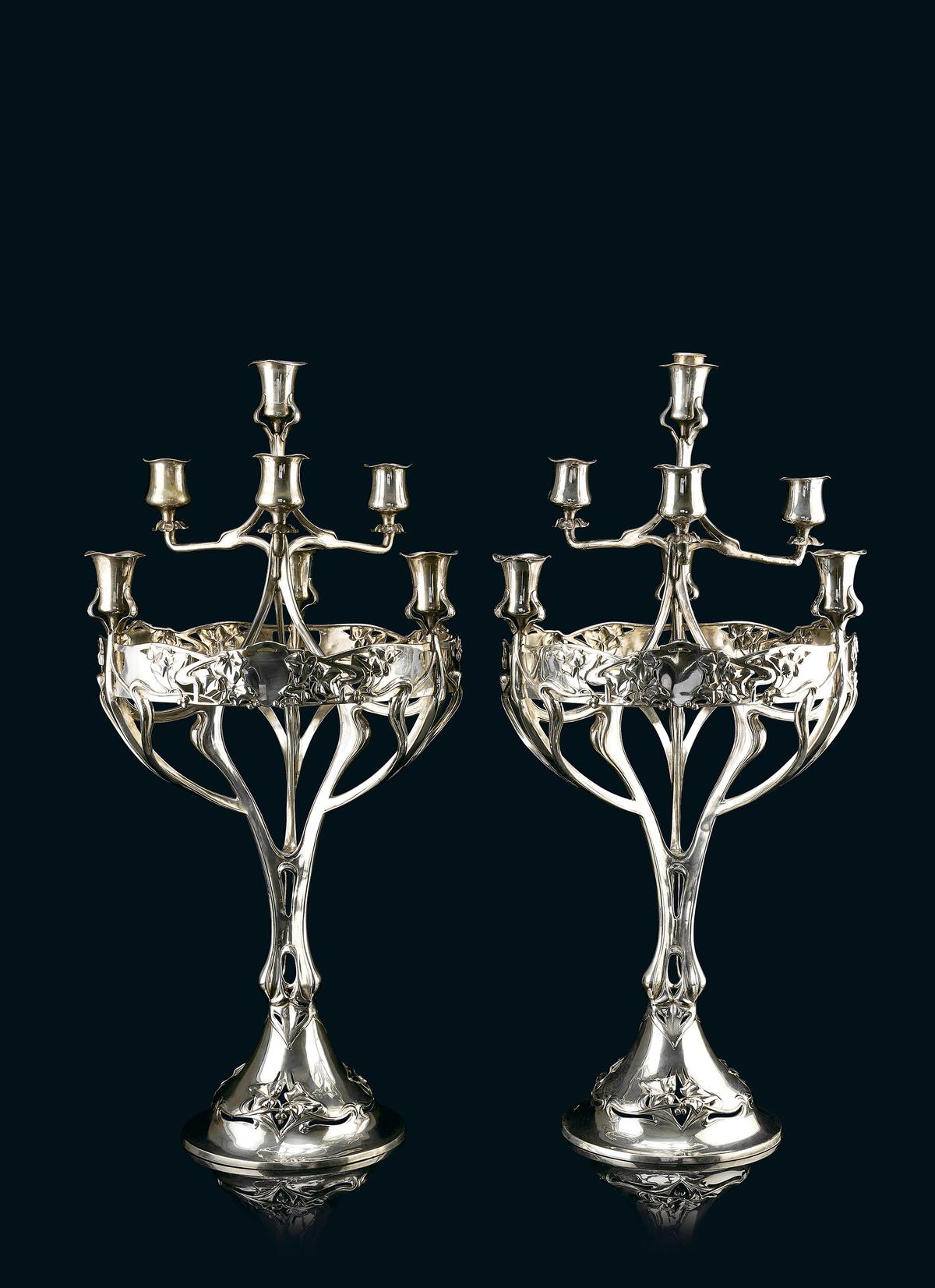 A pair of Art Nouveau silver candelabras by Vietor, Berlin.
Weight: 3.150 kgs;
Size: 24 x 11 x 11 inches each;
Year: 1900;
Estimate: ₹4,00,000-₹6,00,000. A pair of Art Nouveau silver candelabras by Vietor, Berlin.
Weight: 3.150 kgs;
Size: 24 x 11 x 11 inches each;
Year: 1900;
Estimate: ₹4,00,000-₹6,00,000.