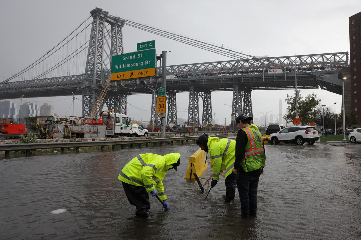 New York City Department of Environmental Protection workers attempt to clear blocked drains after heavy rains as the remnants of Tropical Storm Ophelia bring flooding across the mid-Atlantic and Northeast, at the FDR Drive in Manhattan near the Williamsburg bridge, in New York City, U.S.