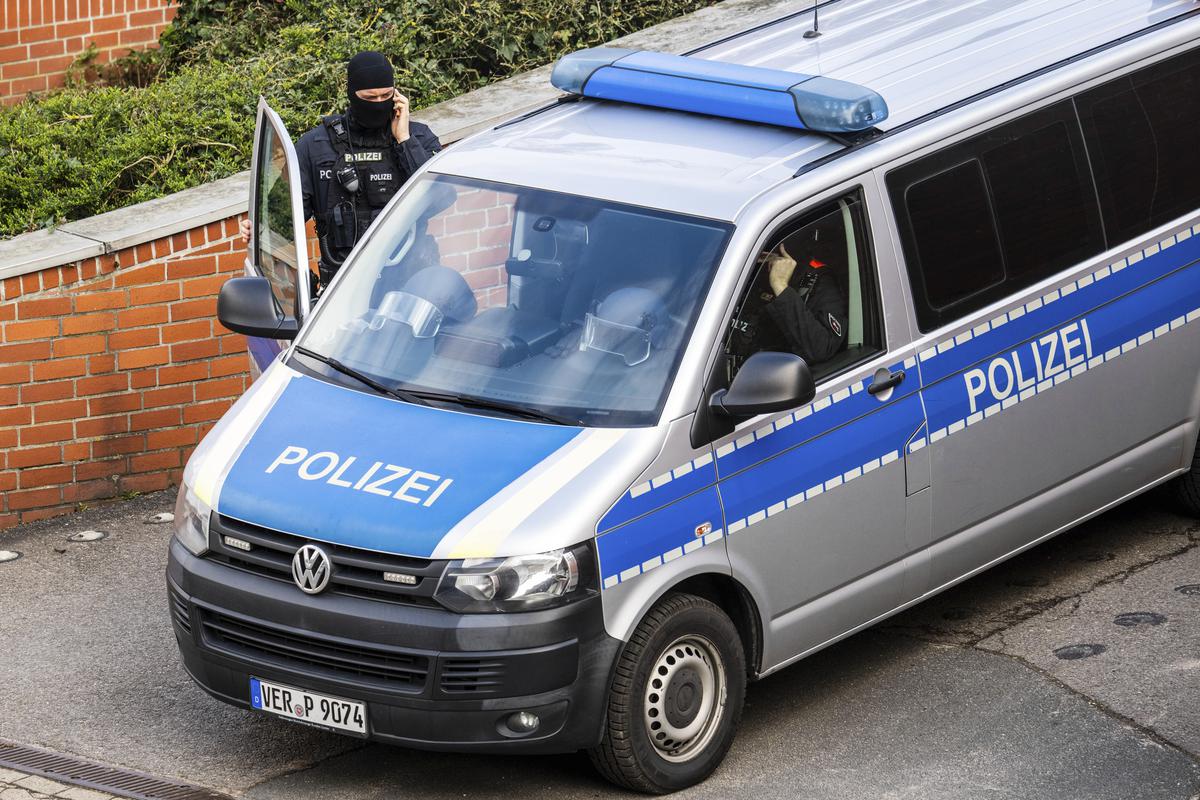 Police officers stand at the entrance of the district court, in Verden, Germany.