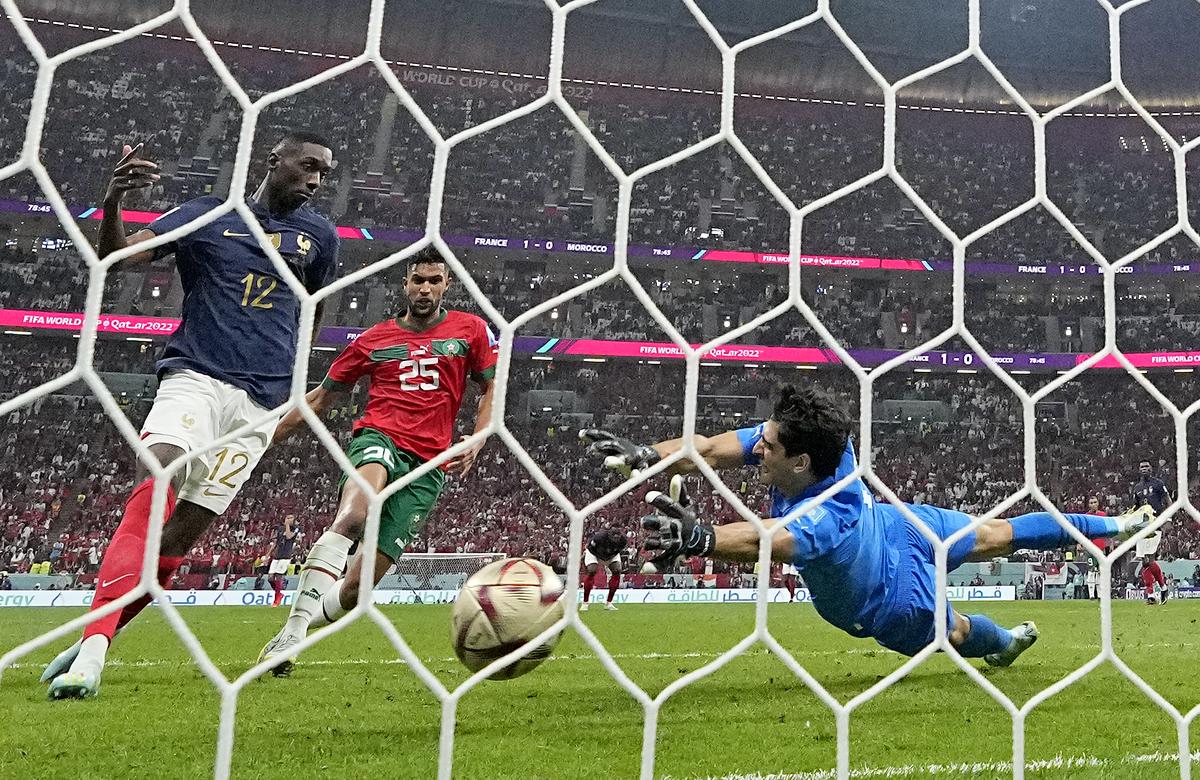 Le Français Randal Kolo Muani marque le deuxième but de son équipe devant le gardien marocain Yassine Bounou lors de la demi-finale de la Coupe du monde de football entre la France et le Maroc au stade Al Bayt à Al Khor, au Qatar, le 14 décembre 2022.