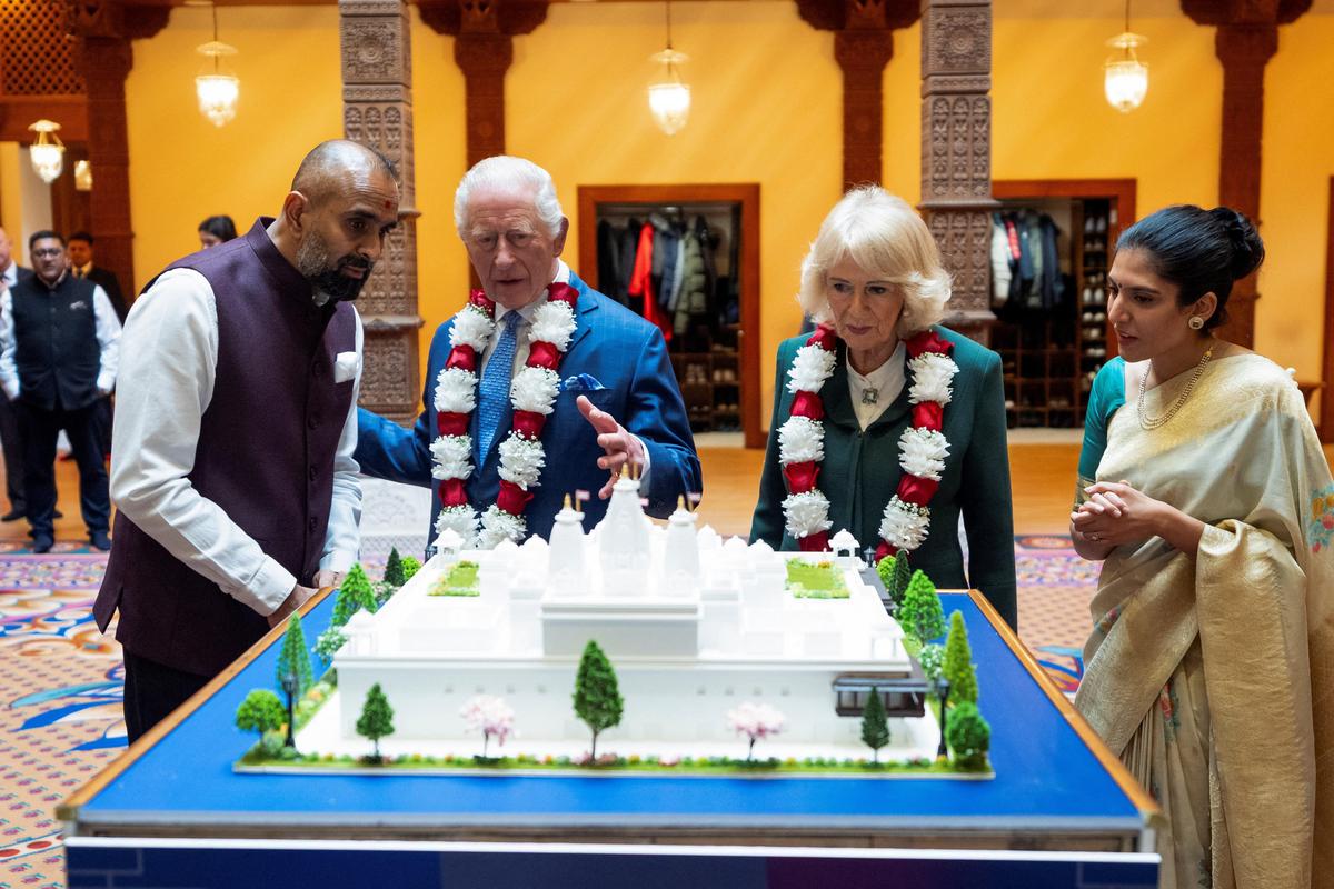 Britain's King Charles III and Queen Camilla view a model of a new temple to be built in Paris, during a visit to BAPS Shri Swaminarayan Mandir