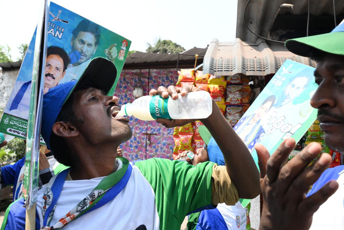 A party worker quenches his thirst with buttermilk, during an election campaign for the YSRCP candidate Vasupalli Ganesh, in Visakhapatnam on April 2, 2024