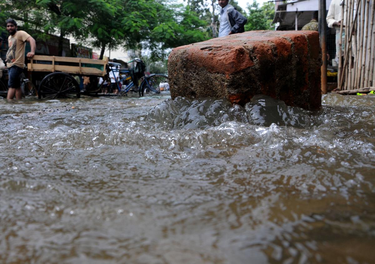 Rain water overflowing from a manhole during the heavy rains at Kodungaiyur in Chennai on December 3, 2015. 