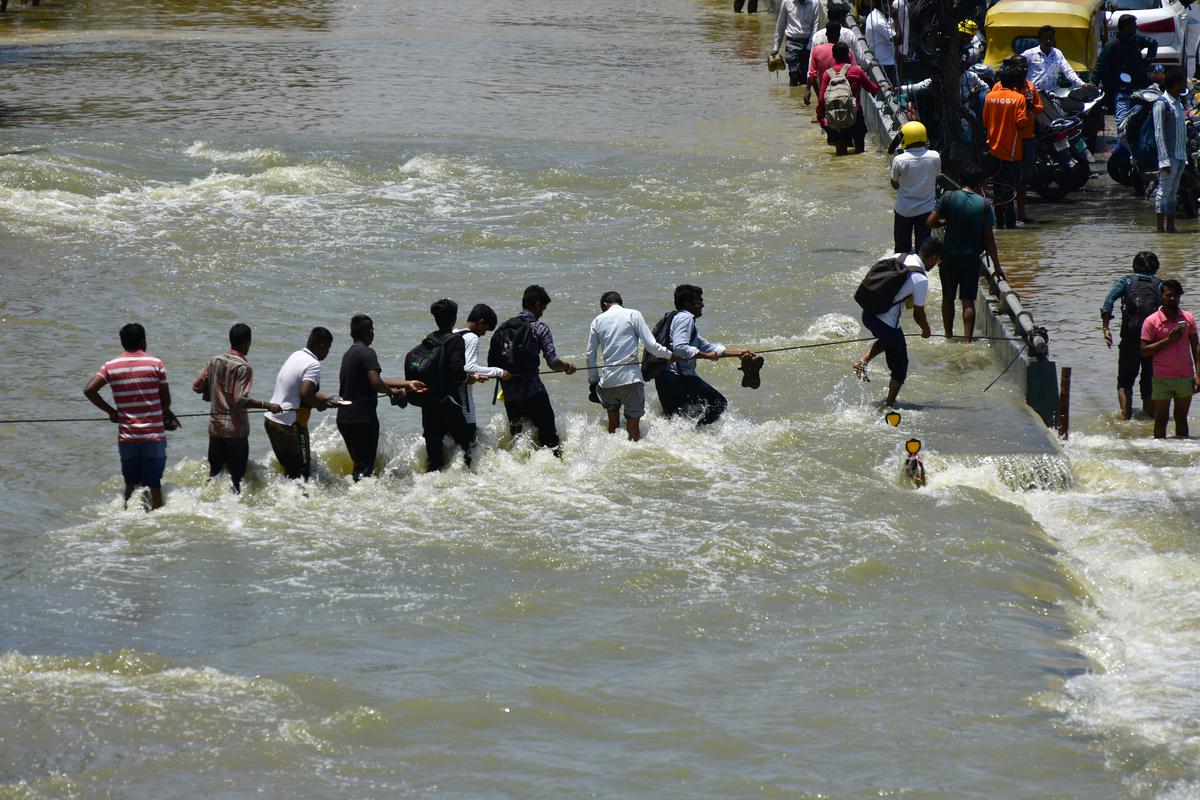 5 सितंबर, 2022 को बेंगलुरु के ओआरआर में लोगों को रस्सी की मदद से बाढ़ के पानी को पार करने की कोशिश करते देखा गया।