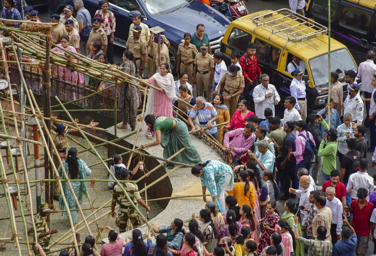 Protestocular, 6 Ağustos 2025'te güvercin beslemesini engellemek için BMC tarafından Mumbai'deki bir Kabutarkhana'daki bir Kabutarkhana'da yerleştirilen branda kapağını yıkmaya çalışıyorlar.