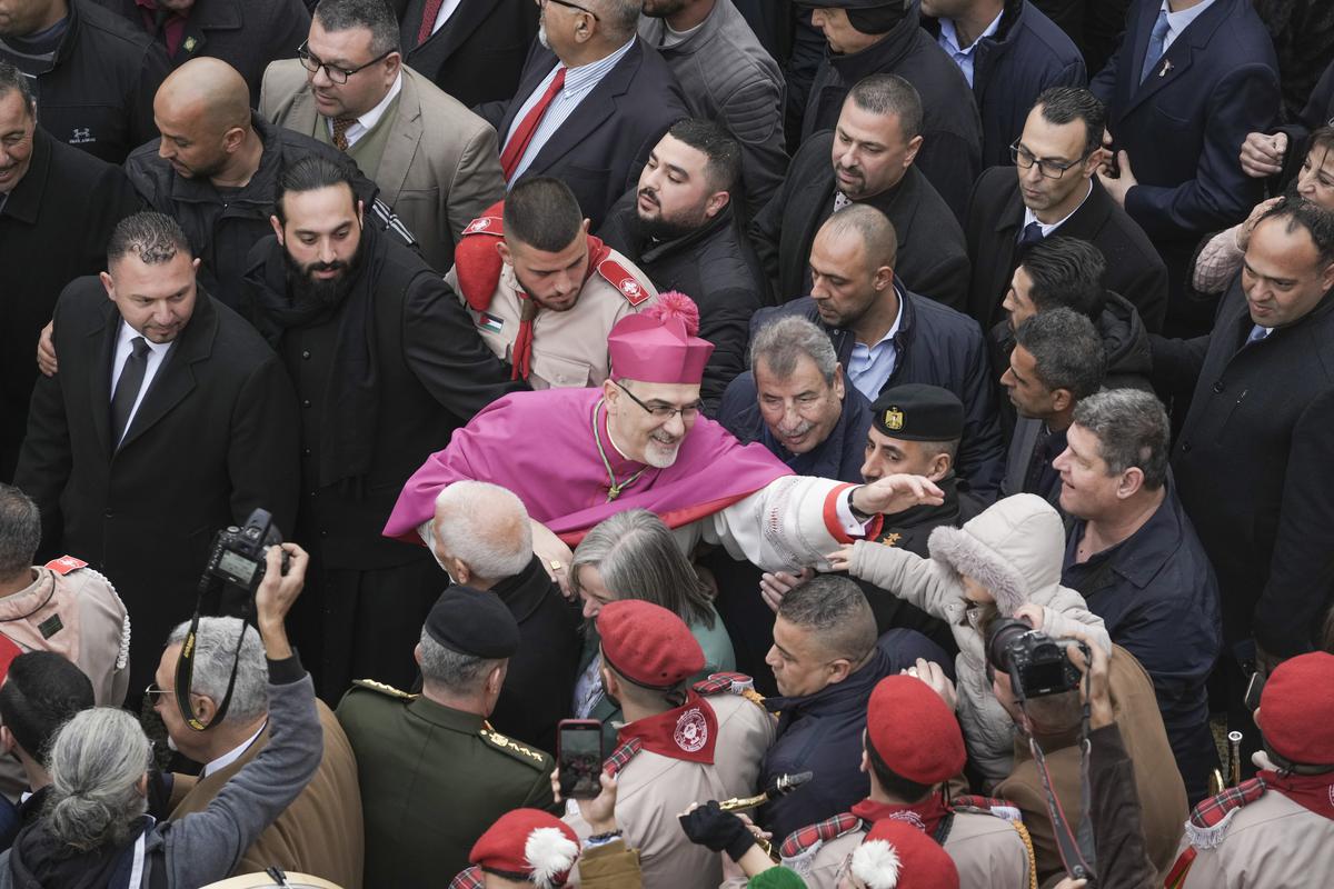 Latin Patriarch Pierbattista Pizzaballa greets worshippers in Manger Square, adjacent to the Church of the Nativity, traditionally believed to be the birthplace of Jesus Christ, in the West Bank town of Bethlehem during Christmas celebrations on December 24, 2022.