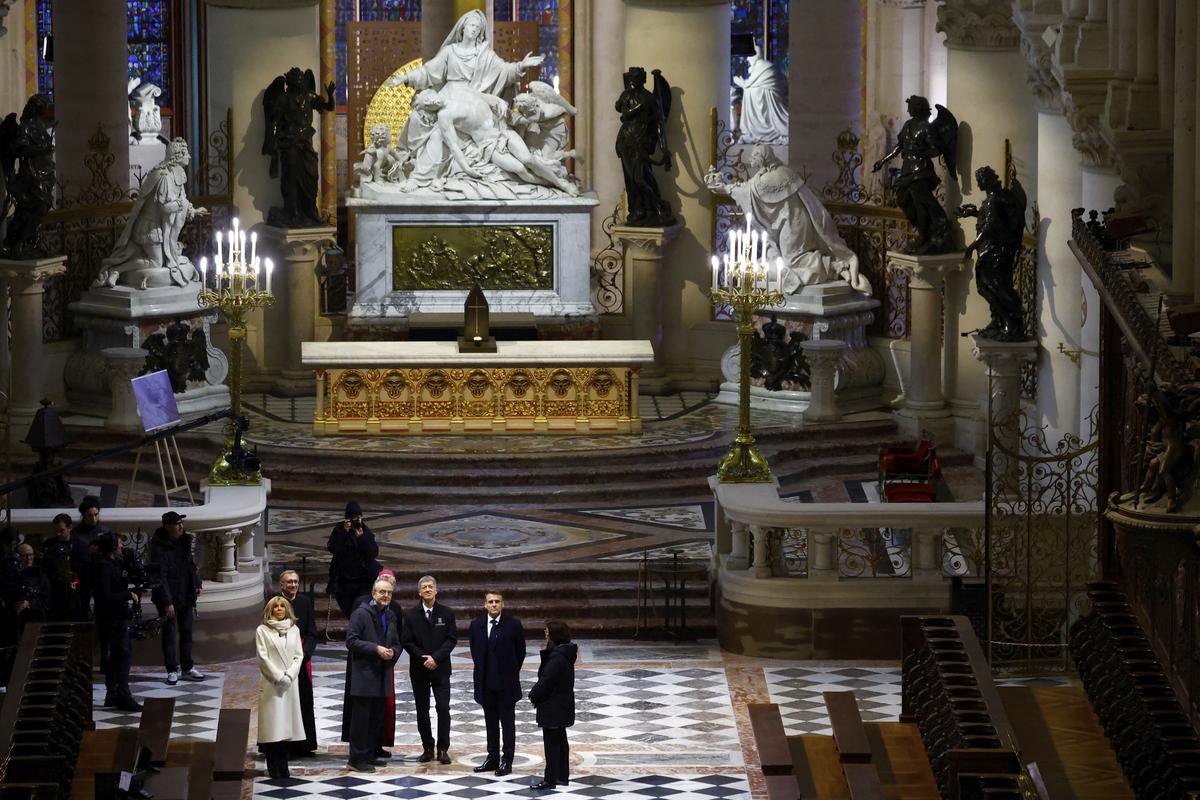 French President Emmanuel Macron, second right, and his wife Brigitte Macron visit the restored interiors of the Notre-Dame de Paris cathedral