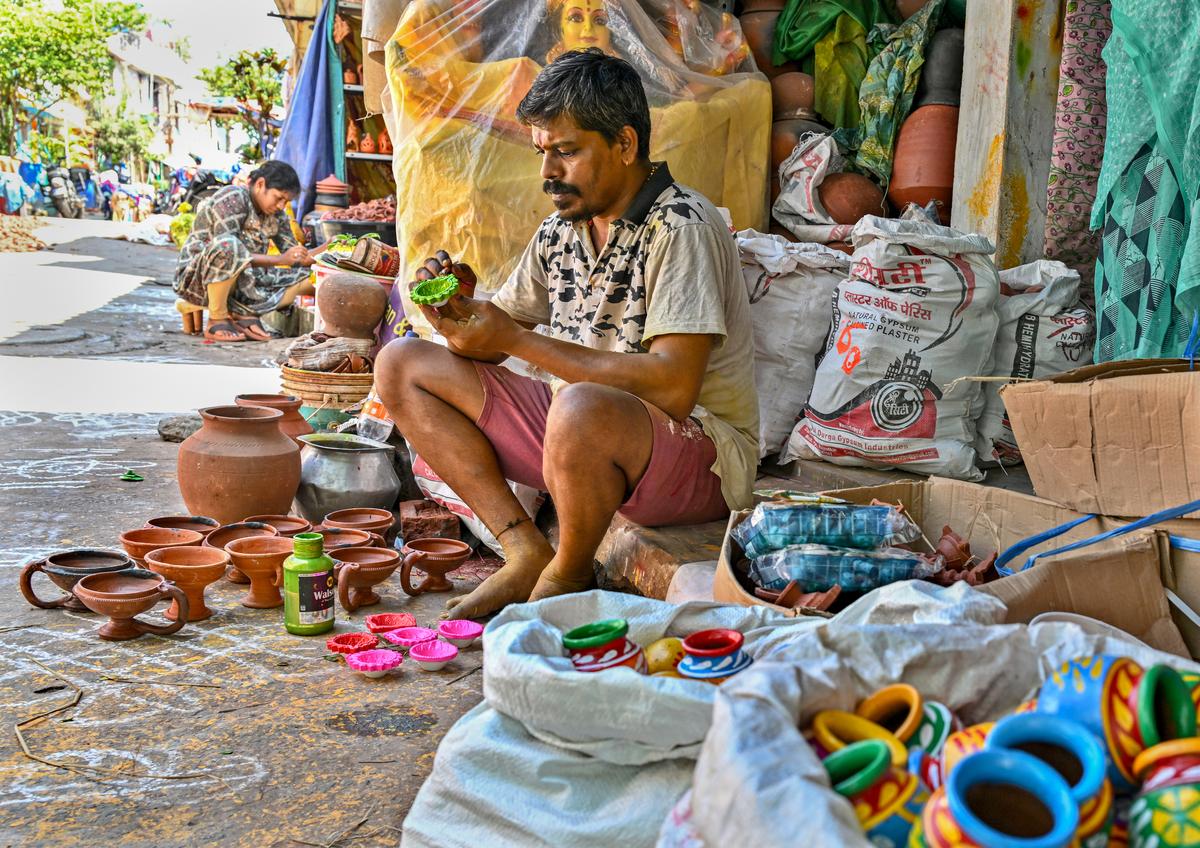 Gowri Shankar paints deepams in front of his houses, ahead of Deepavali, at Kummari Veedhi (potters’ street) in Visakhapatnam. Gowri Shankar paints deepams in front of his houses, ahead of Deepavali, at Kummari Veedhi (potters’ street) in Visakhapatnam.