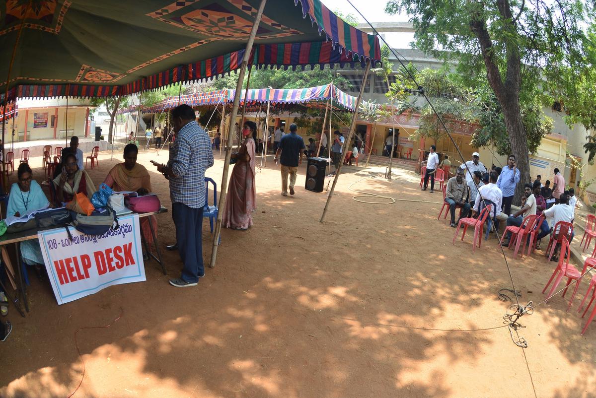 Postal ballot voters waiting under a tree shed, to cast their votes, on a hot summer day. 