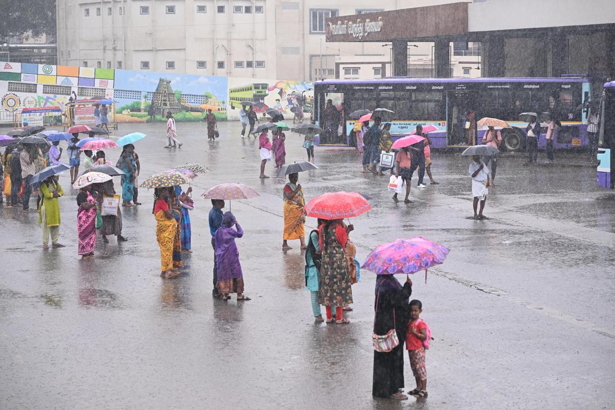 Amidst rain, commuters waiting for buses at Periyar bus stand in Madurai on Tuesday morning.