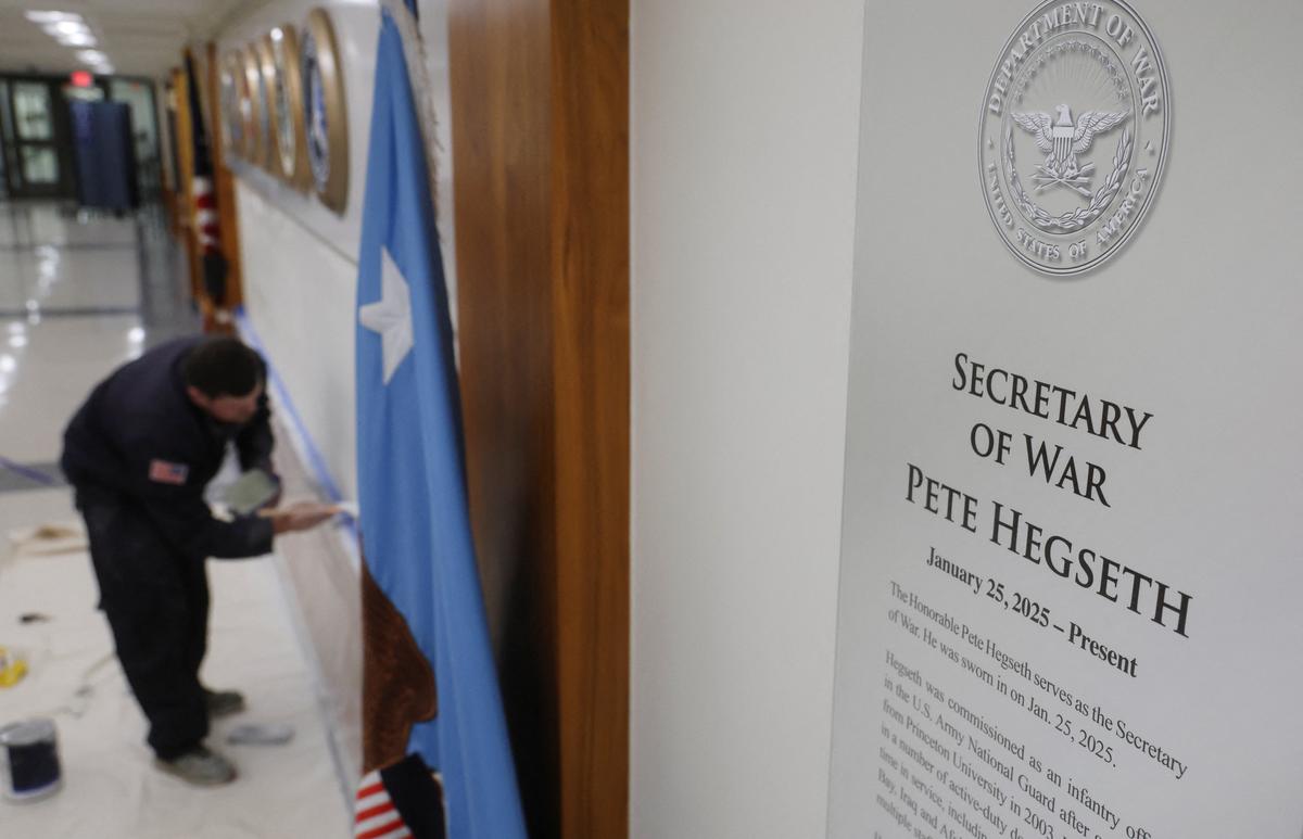 A sign that reads “Pete Hegseth - Secretary of War” hangs as a worker prepares a wall for new signs after U.S. President Donald Trump ordered the Department of Defence to be renamed as the “Department of War”, at the Pentagon in Washington.