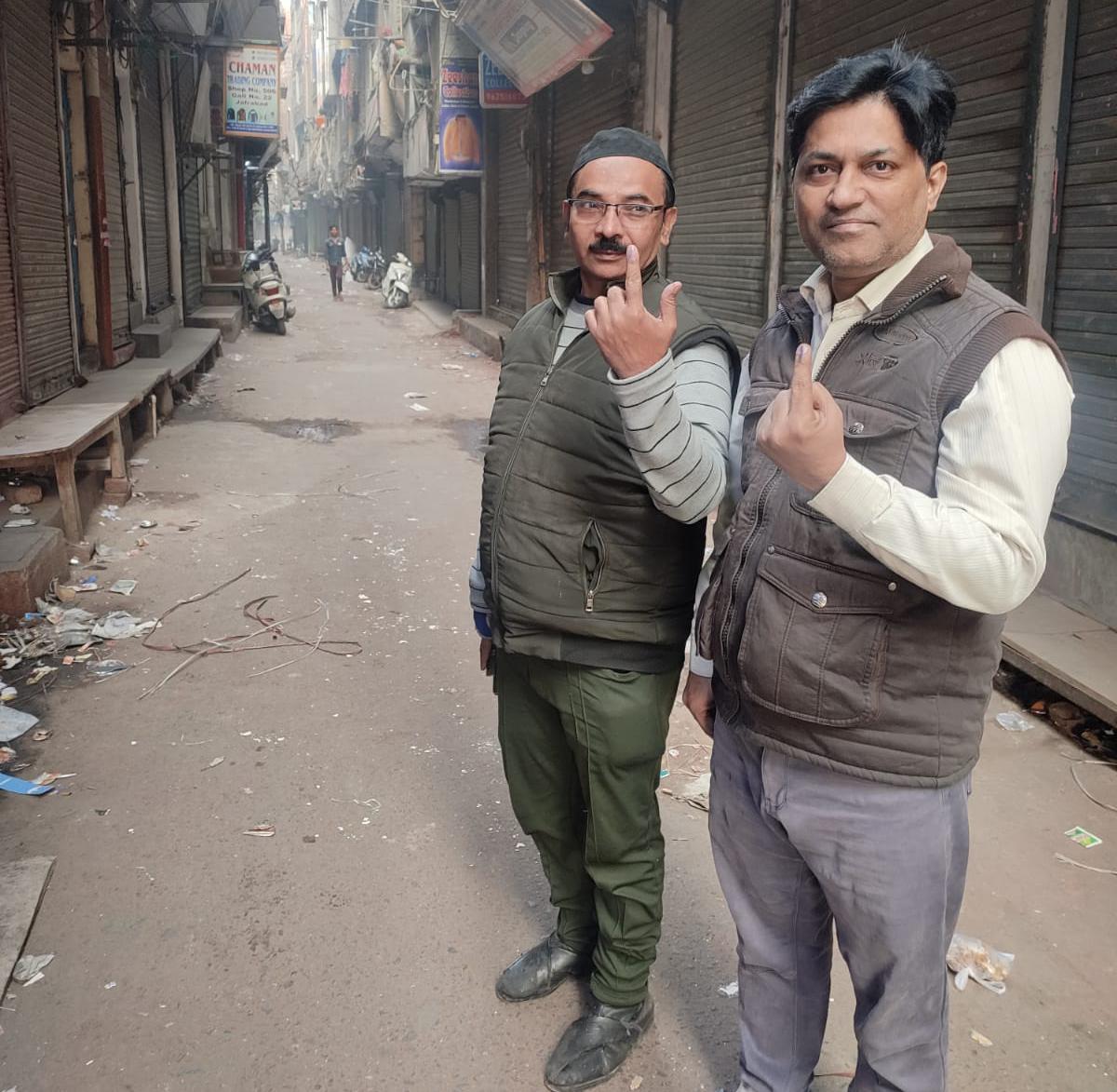 People showing ink mark after casting their vote during Delhi MCD Polling in New Delhi on December 4, 2022.