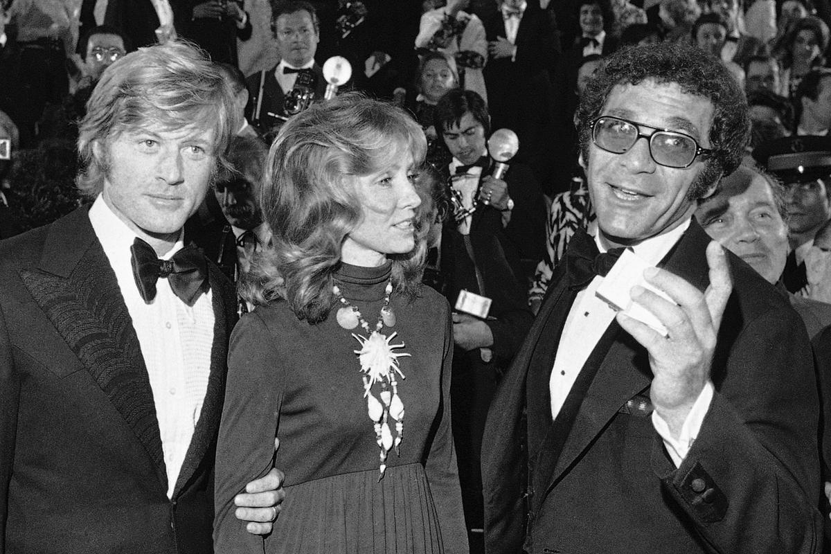 (left) Robert Redford, wife Lola, and director Sydney Pollack appear at the presentation of the film ‘Jeremiah Johnson’ during the Cannes Film Festival in Cannes, France on May 7, 1972.
