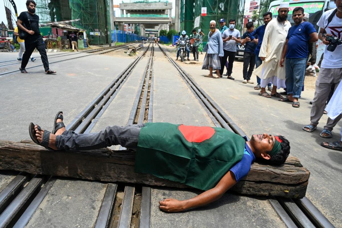 A student blocks a rail track during a protest to demand a merit-based system for civil service jobs in Dhaka on July 10, 2024. 