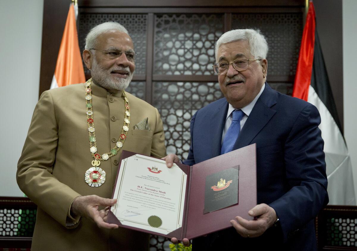Palestinian President Mahmoud Abbas, right decorates Indian Prime Minister Narendra Modi with the Grand Collar of the State of Palestine medal, during his visit to the Palestinian Authority headquarters in the West Bank city of Ramallah, Saturday, Feb. 10, 2018.