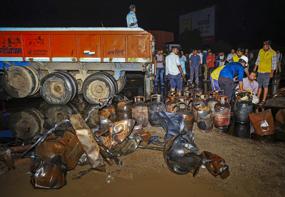 People gather after a truck carrying LPG cylinders caught fire following a collision with a tanker on the Jaipur-Ajmer highway, early Wednesday, Oct 8, 2025.