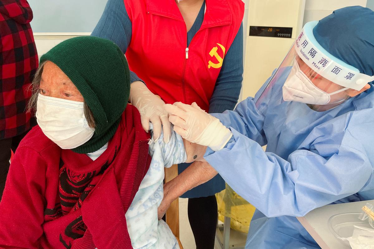 A medical worker administers a dose of a vaccine against COVID-19 to an elderly resident, during a government-organised visit to a vaccination center in Zhongmin village on the outskirts of Shanghai, China on December 21, 2022
