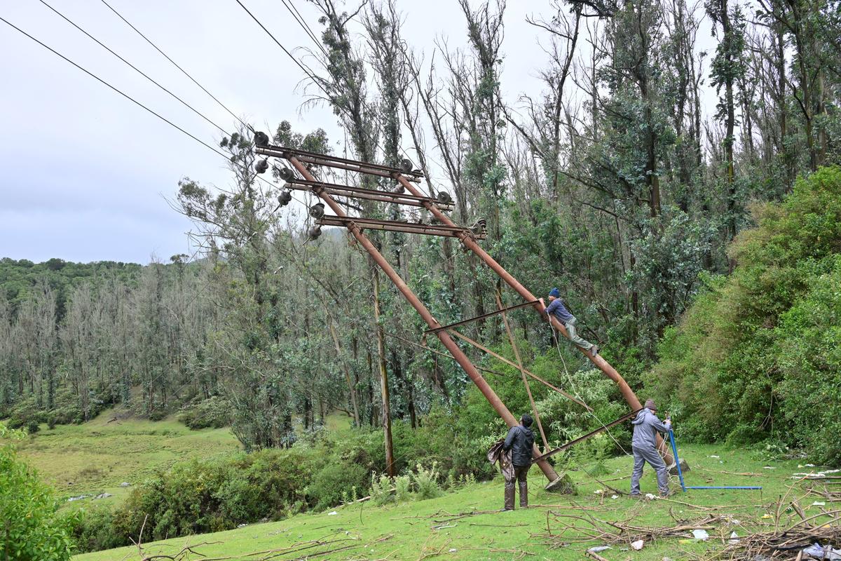 A TNEB staff fixing a high tension electricity pole at Sholur Junction near Udhagamandalam on Tuesday.