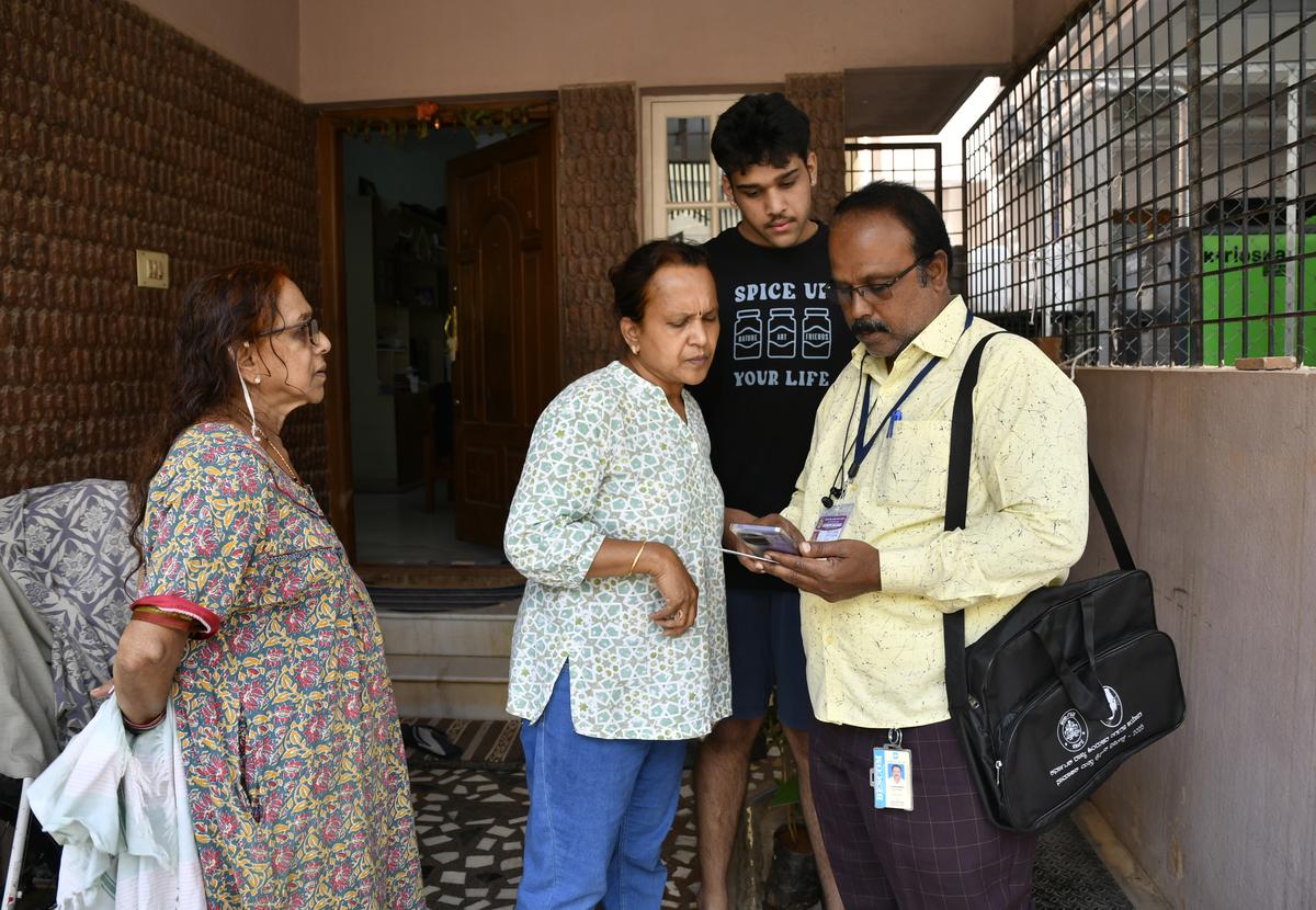 An enumerator interacting with residents during the ongoing Social and Educational Survey at Bhuvaneswari Nagar in Bengaluru on Sunday.