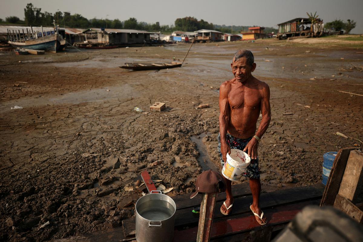 Fisherman Raimundo da Silva do Carmo, 67, collects water from a well on Puraquequara Lake, which has been affected by drought, in Manaus, Brazil, October 6, 2023. 