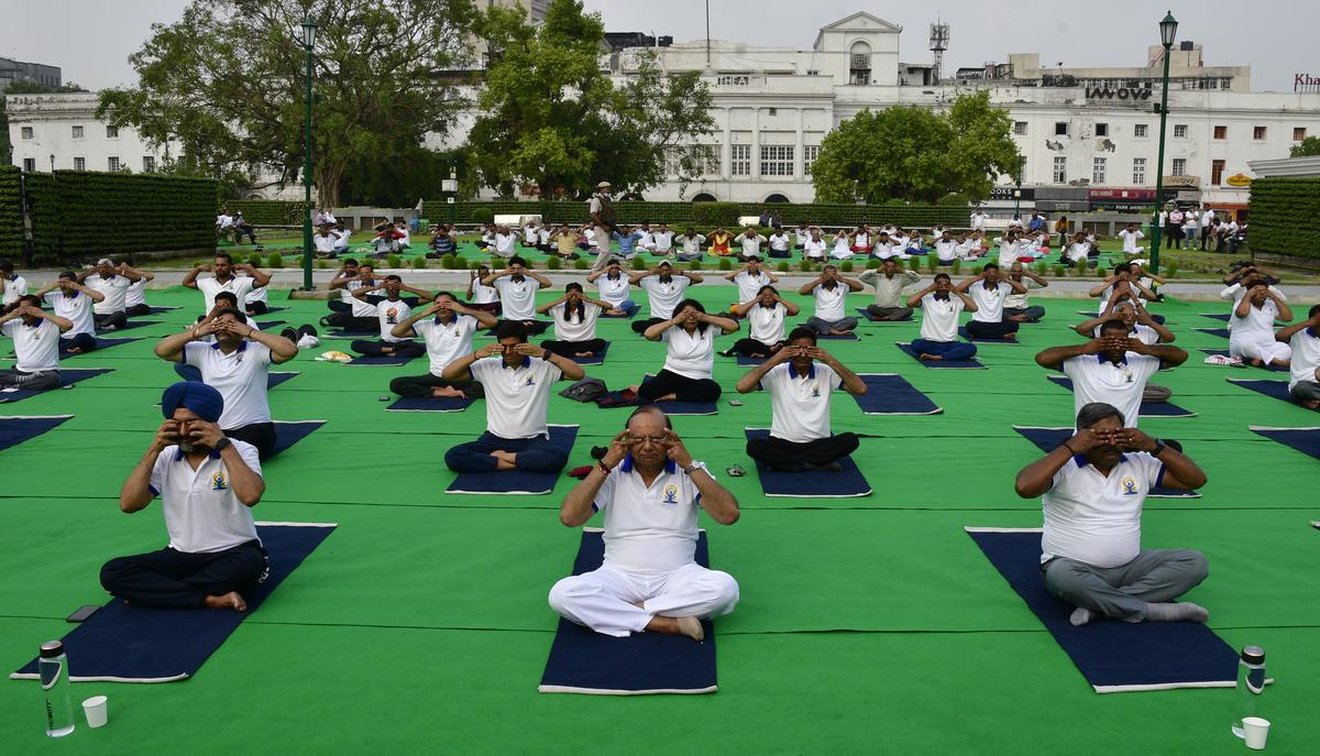 Delhi Lt. Governor V.K. Saxena performing yoga during the International Yoga Day at the Connaught Place in New Delhi on Tuesday, June 21, 2022. 