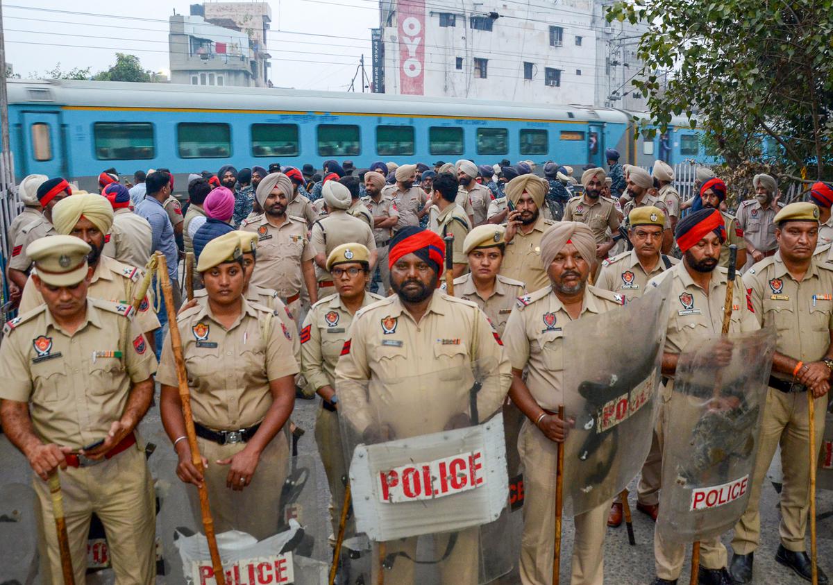 Police personnel stand guard to stop Shiv Sena protesters over the killing of Sudhir Suri, in Amritsar.