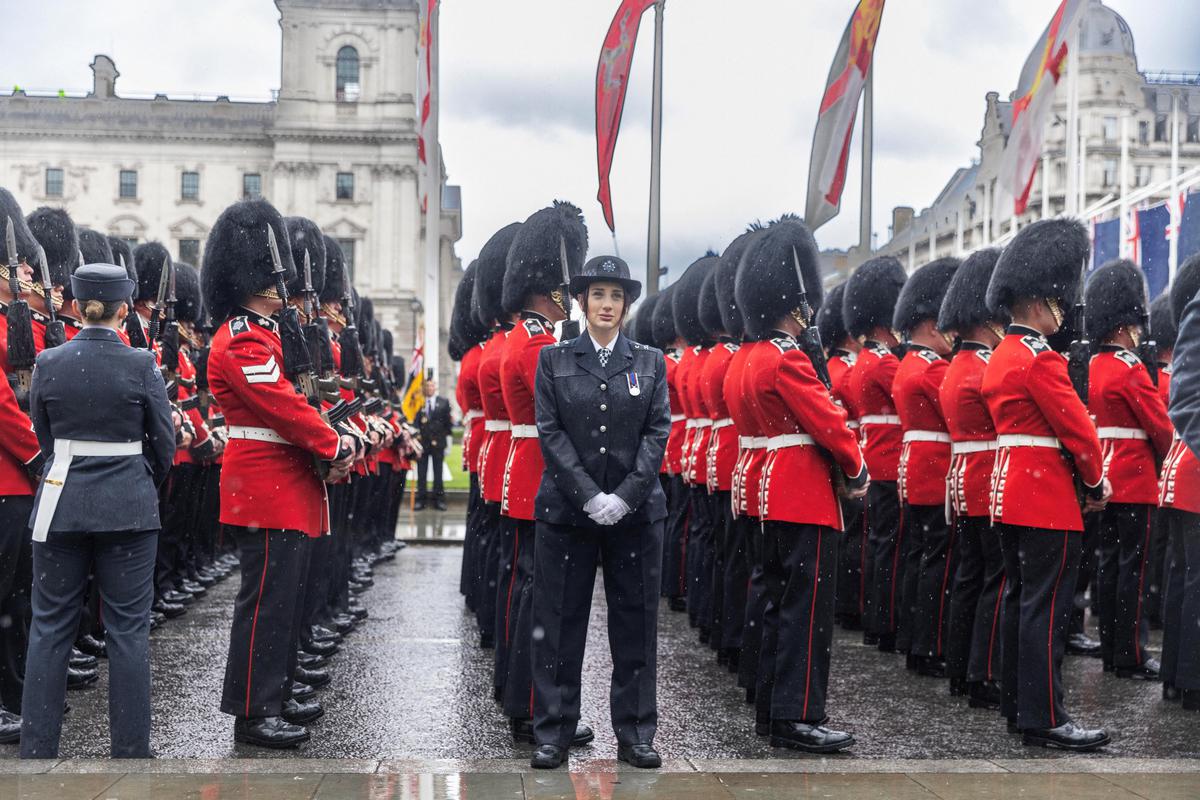 Police officers and ceremonial guards waiting in the rain for King Charles and Queen Camilla to leave Westminster Abbey after their coronation on May 6, 2023.