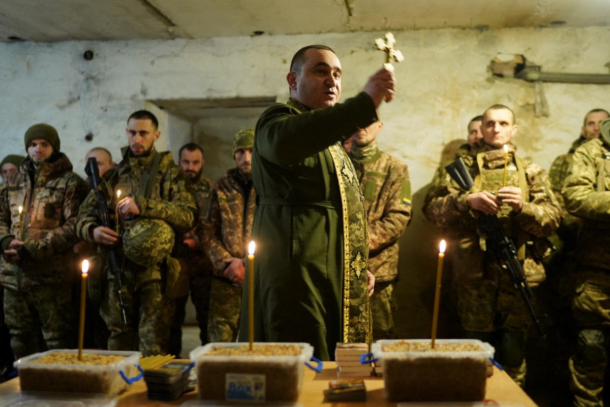 A military Orthodox chaplain conducts a Christmas Eve mass for service members of the 72nd Chorni Zaporozhtsi Separate Mechanized Brigade of the Ukrainian Armed Forces, amid Russia’s attack on Ukraine, at a position in a front line in Donetsk region on December 24, 2024. 