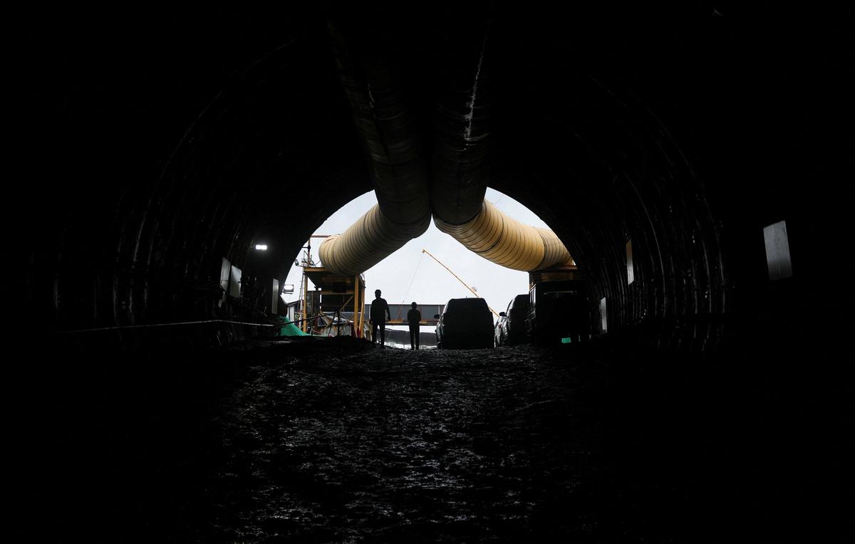 People stand at the entrance of a tunnel, completed as part of the Mumbai–Ahmedabad bullet train project in Navi Mumbai, on September 20, 2025.