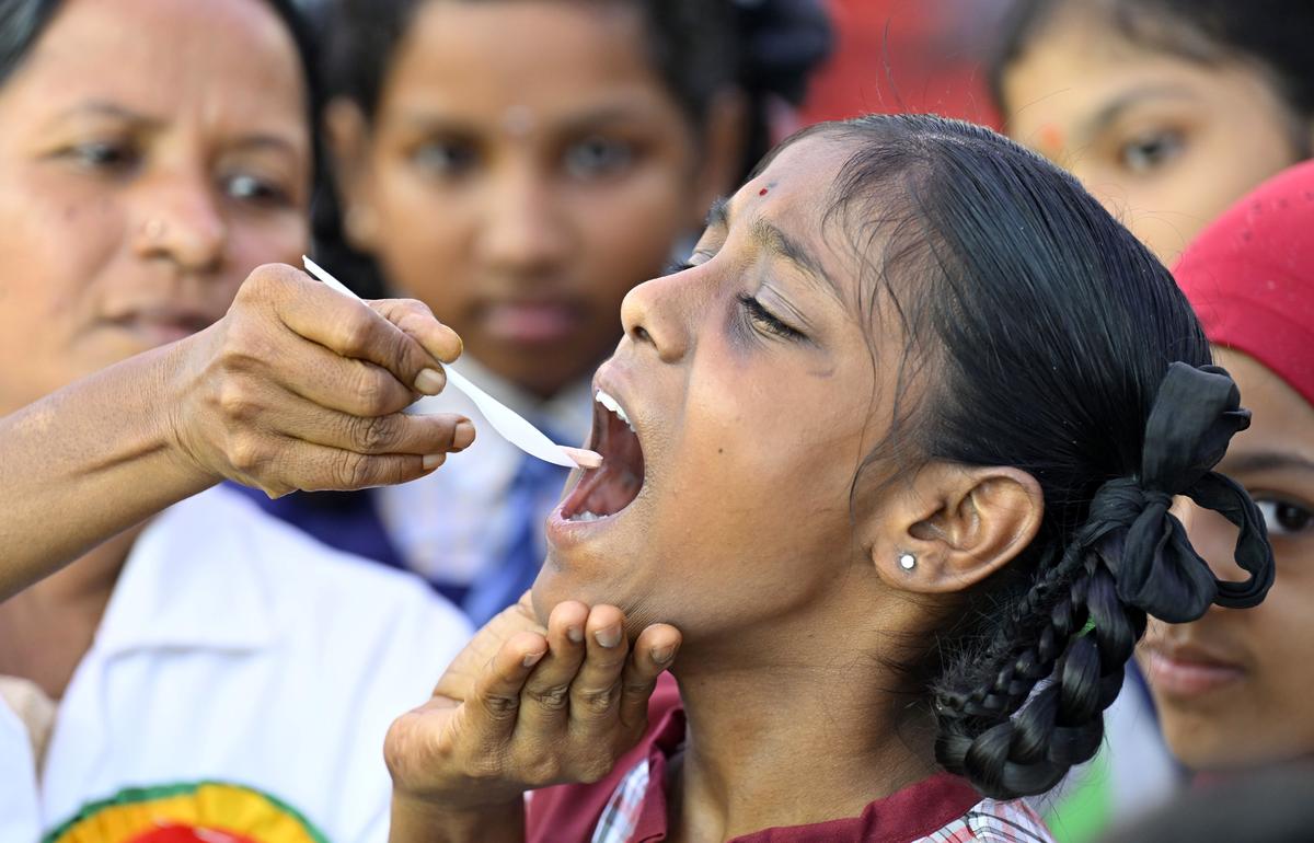 A healthcare worker administers Albendazole tablet to a school girl on National Deworming Day at Raj Bhavan School, Somajiguda, on Thursday.