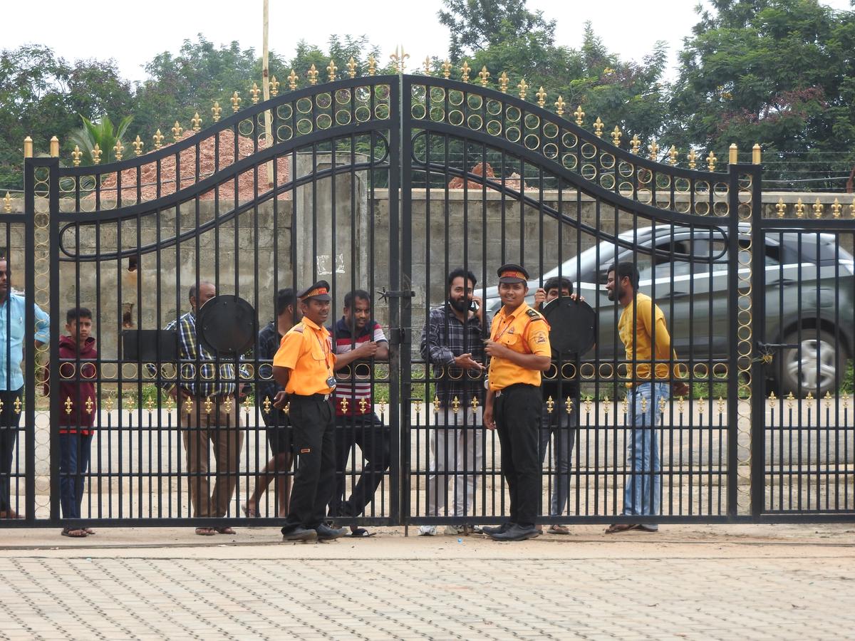 Fans, who had come to watch India cricketer Sanju Samson in action for Kerala against Karnataka in the Ranji Trophy at the Alur Grounds near Bengaluru in October 2024, are stopped by security guards. 
